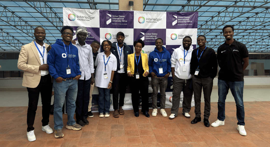 Participants at USIU-Africa pose in front of a banner featuring Interledger Foundation and USIU-Africa logos.